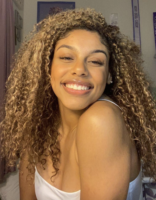 A reviewer showcasing their beautifully defined curly hair.