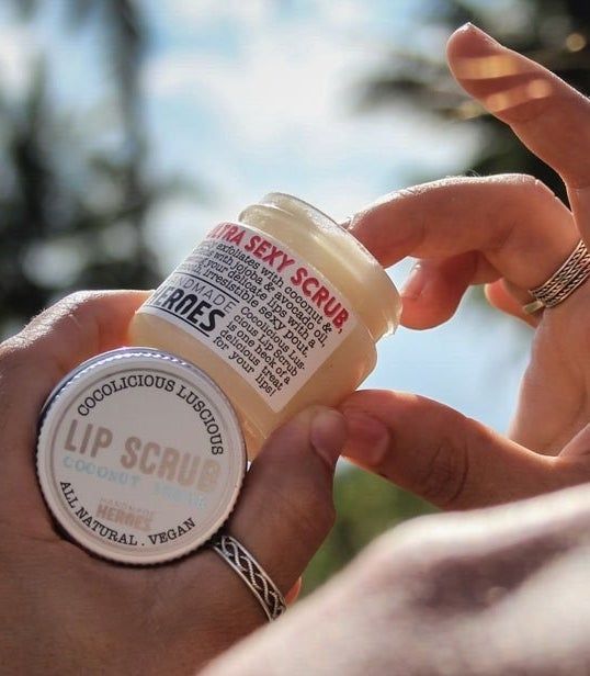 a hand scooping product from a white jar