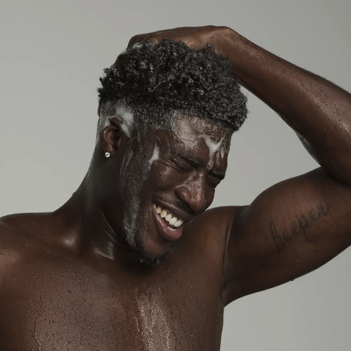 A model washing their hair with the products from the kit.