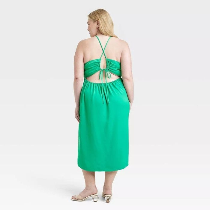A model wearing a green dress, showcasing its back view.