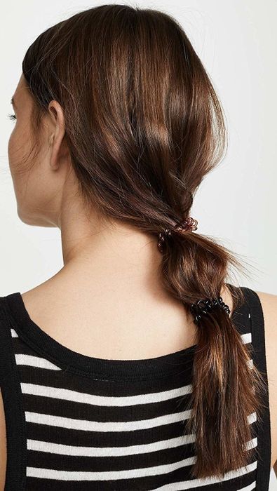 A model showcasing the black hair coil in use.