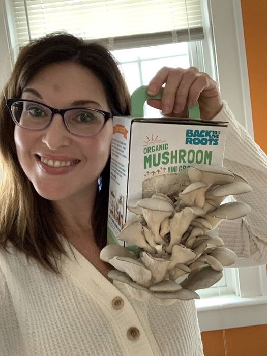 The reviewer proudly presents her mushroom kit, filled with healthy, white mushrooms.