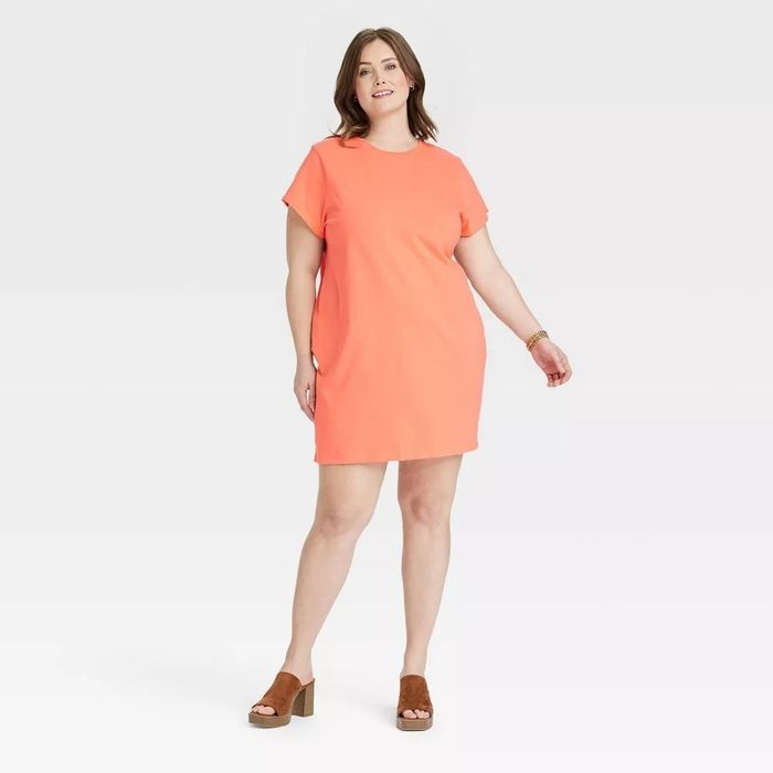 A model is shown wearing an orange dress.