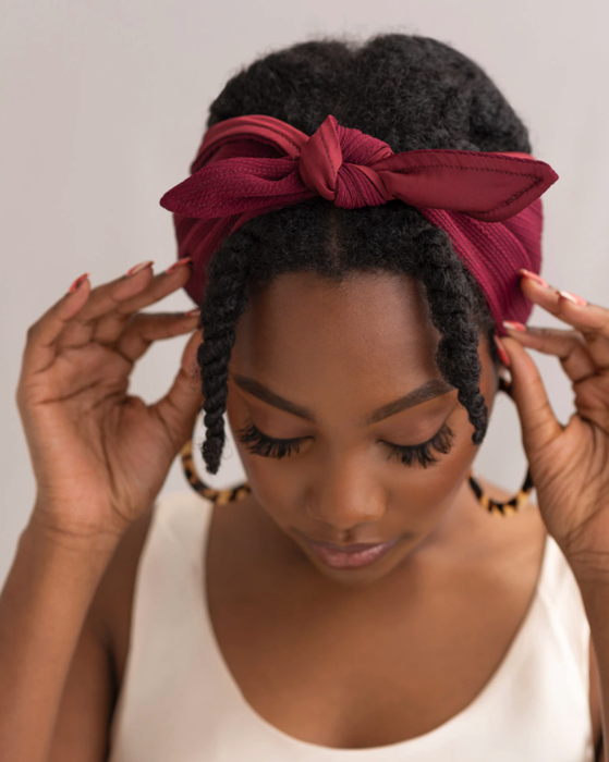 A model with kinky hair wearing the bandie in red.