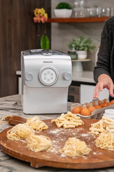 The pasta maker with freshly made tube and spaghetti pasta