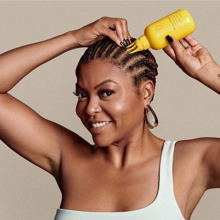 Actress Taraji P. Henson applying the scalp conditioner to her scalp directly from the bottle.