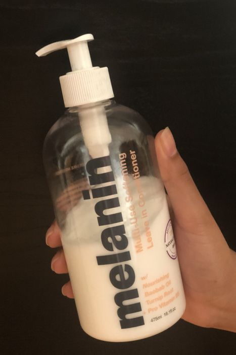 A hand holding the pump bottle of the product.