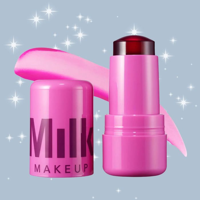 Milk Makeup's lip and cheek stick in pink packaging, displayed against a glittery backdrop with a swatch of the product visible