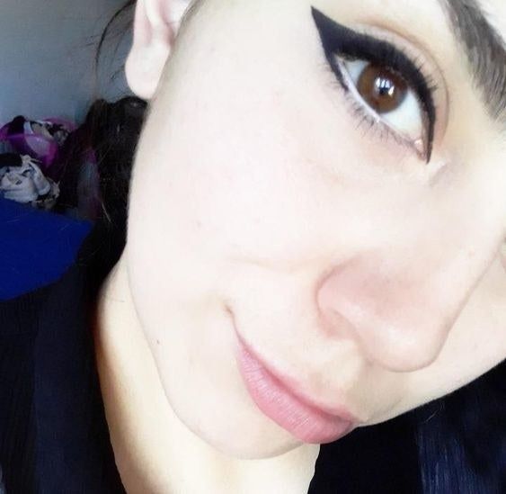 A reviewer showing off bold winged eyeliner in black.