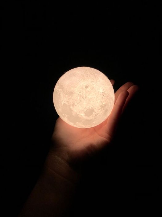 Reviewer is holding the moon-shaped light in their hand