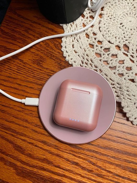 Earbuds charging on the sleek wireless charger