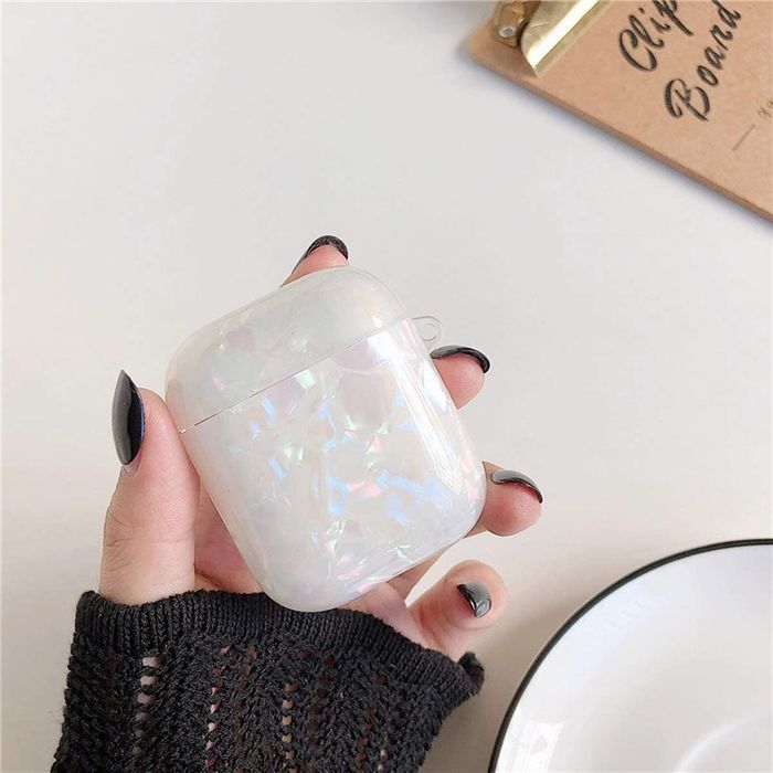 Model showing off the white, iridescent AirPods case with style