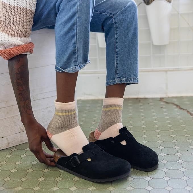 A person slipping clogs on over their socks