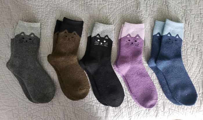 Five pairs of socks featuring adorable cat faces at the top.