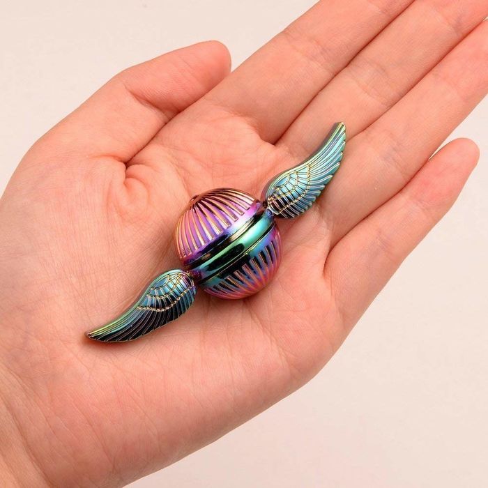 A rainbow-colored spinner shaped like a Flying Snitch, complete with wings sprouting from the sides