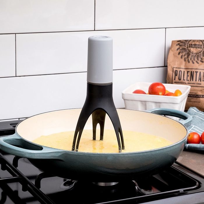 The three-pronged stirrer being used in a pan