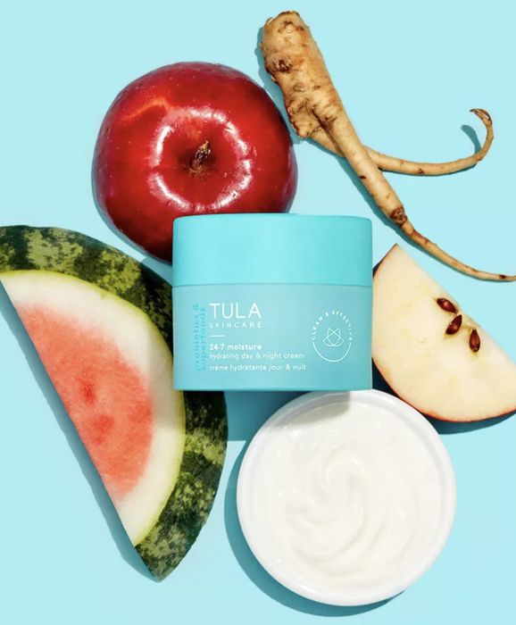 The moisturizer arranged on a flat lay alongside fresh fruits and vegetables