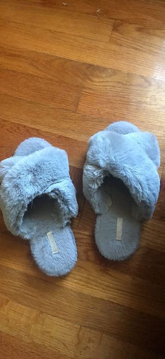 The reviewer's slippers are made of soft grey faux-fur.