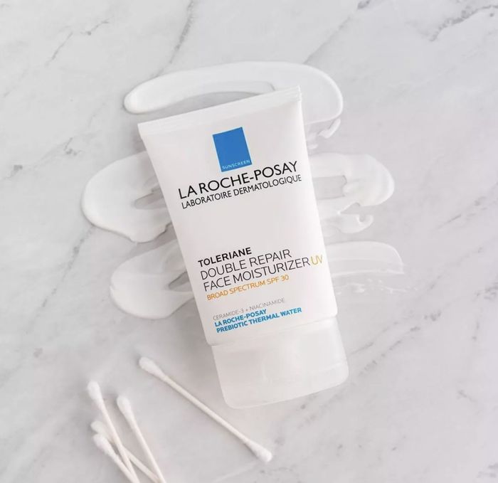 The product in its tube on a counter next to cotton swabs