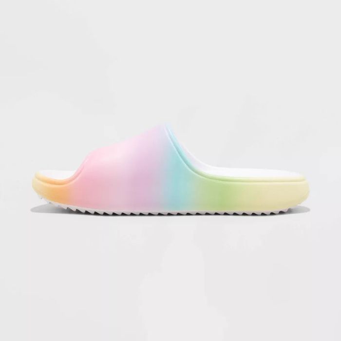 A single, rainbow-colored slide sandal with a textured sole, set against a plain background