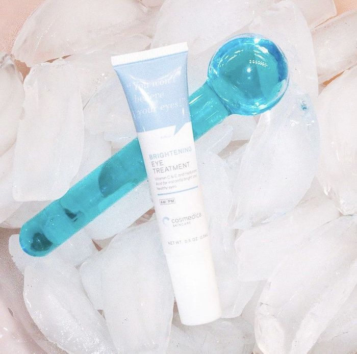 The eye cream and ice globe roller resting in ice