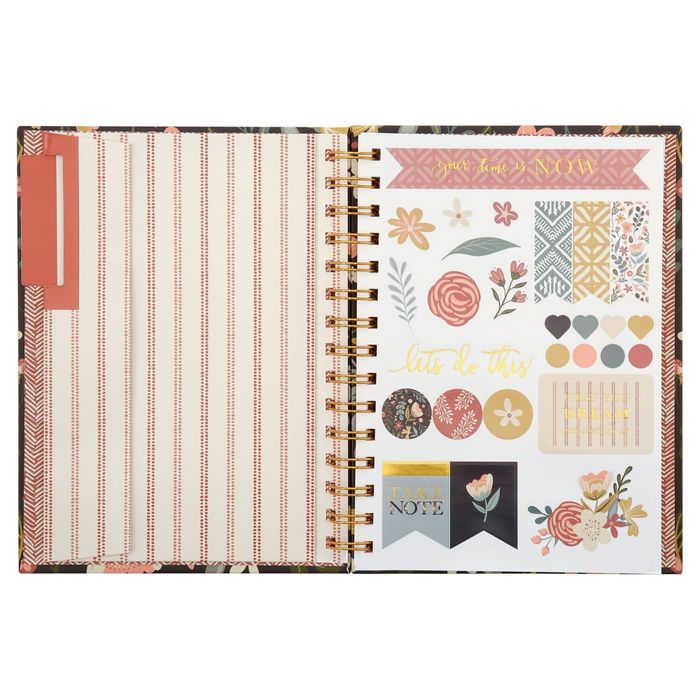 An open planner decorated with stickers, including flowers, hearts, and motivational phrases, perfect for journaling or scrapbooking