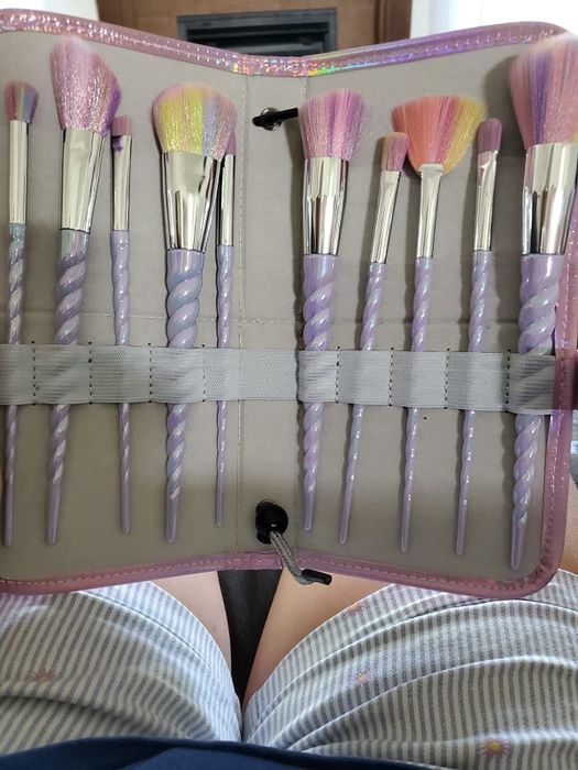Reviewer's set of rainbow-colored makeup brushes, complete with unicorn horn handles
