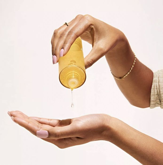 A person pouring toner into their palm