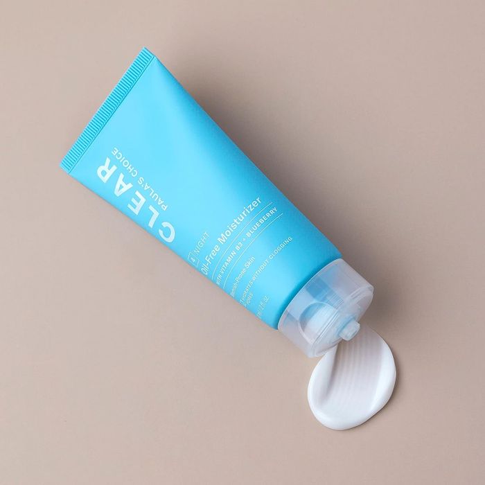 The moisturizer bottle with some of its contents squeezed out.