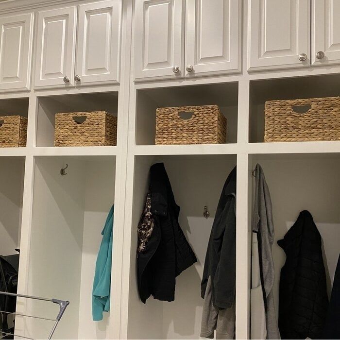 Another reviewer's photo of the baskets placed in a mudroom for extra storage.