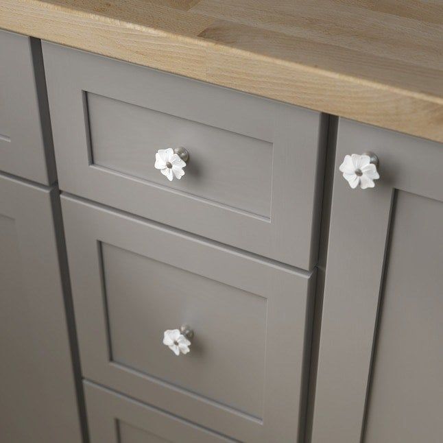 Floral-designed knobs adorning cabinet drawers.