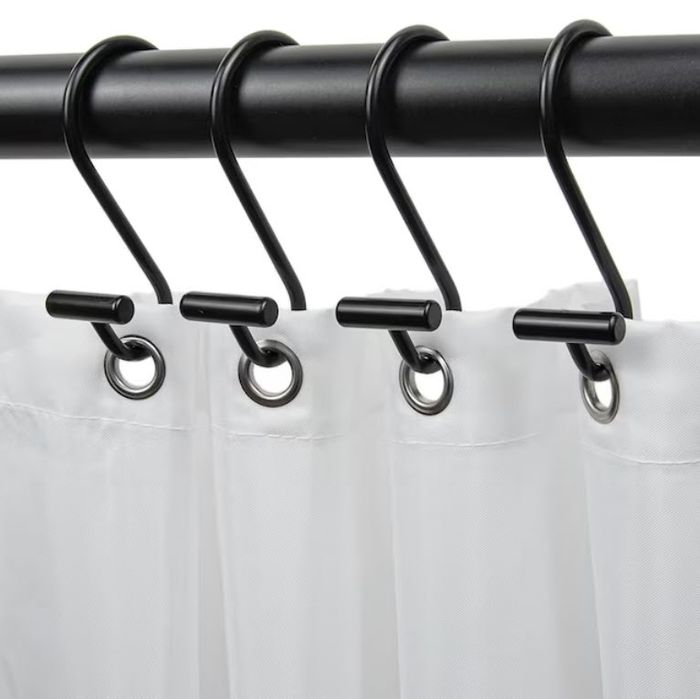 Four black shower curtain rings suspended from a rod, each securing a portion of a white shower curtain.