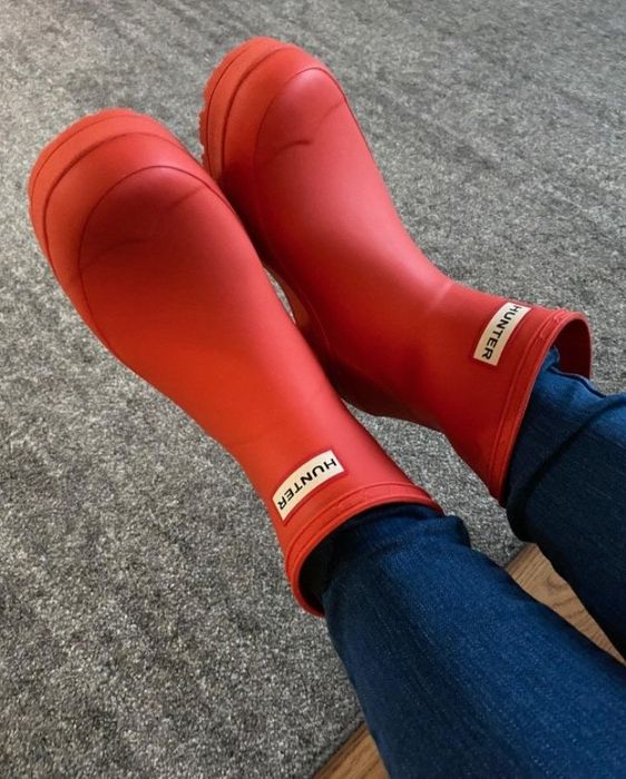 A reviewer rocking the boots in vibrant orange