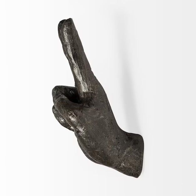 A sleek, dark sculpture of a hand pointing upward, perfect for contemporary interior design