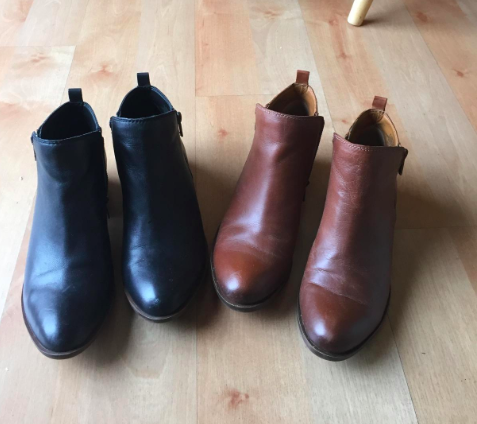 A reviewer's photo showcasing a black and brown pair of the boots.