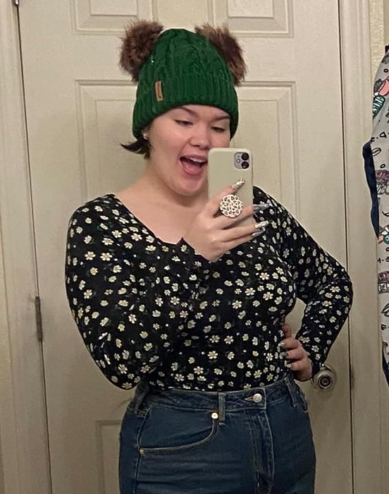 A reviewer is styled in the long-sleeve bodysuit featuring a daisy print.