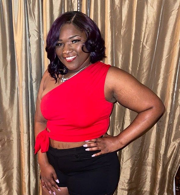 A reviewer models a striking red top.