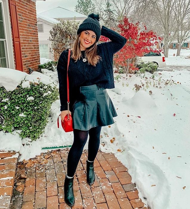 A reviewer models a black skirt.