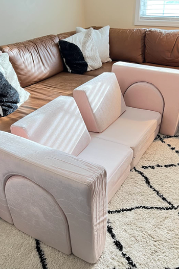 A reviewer’s couch set up as a cozy seating area beside an adult-sized sofa.