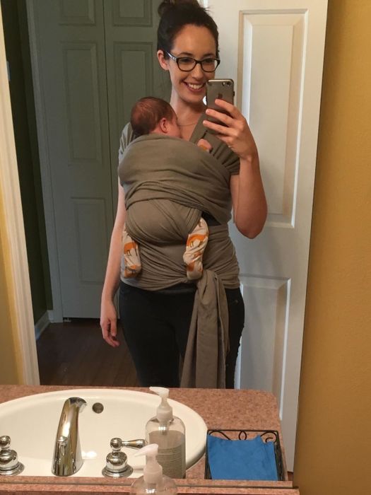 A reviewer’s photo showcasing their baby comfortably carried in the grey wrap.