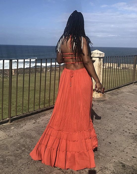 A reviewer wearing a vibrant orange dress