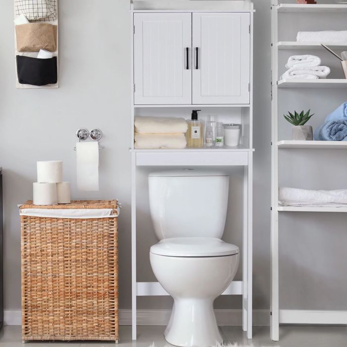 The white cabinet mounted above the toilet.