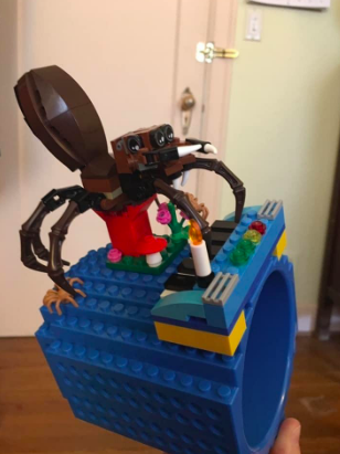 Reviewer showing a spider made out of blocks on top of the cup