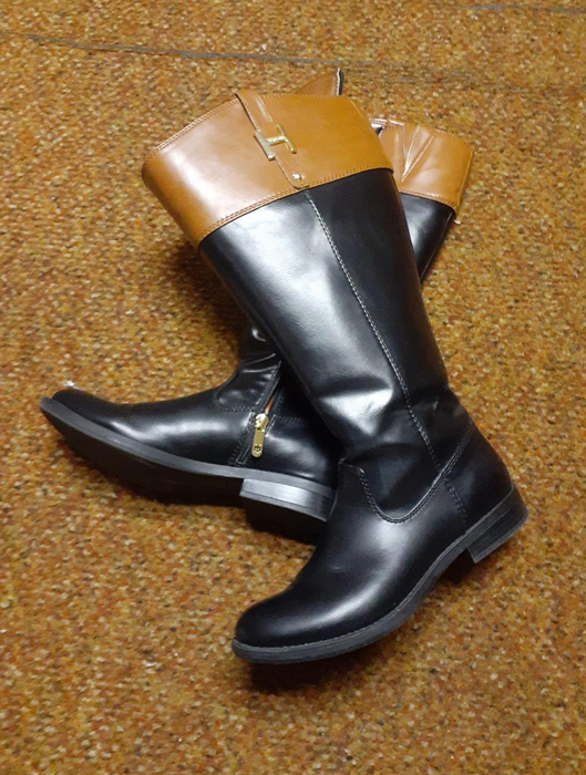 A reviewer’s image of black and tan knee-high equestrian boots.