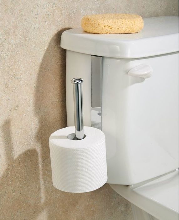 A silver toilet paper holder mounted on the toilet