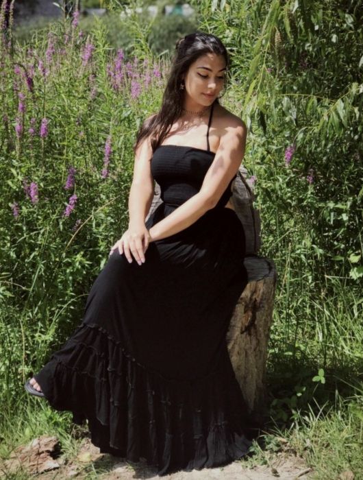 A reviewer wearing a sleek black dress