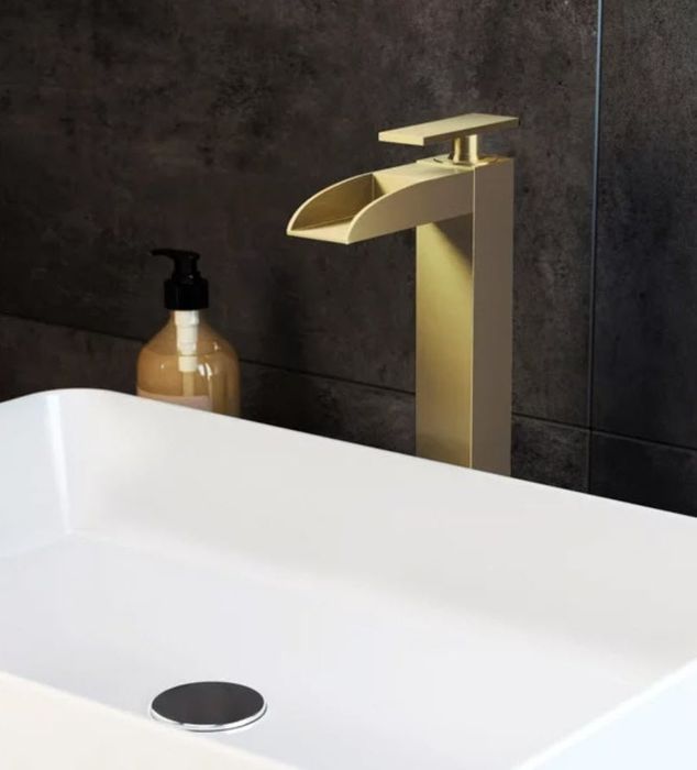 A luxurious gold waterfall faucet installed above a sink.