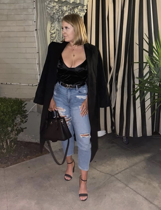 A reviewer styling the black top with jeans and a blazer