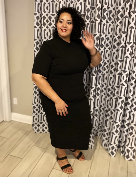 A reviewer wearing the black midi dress.