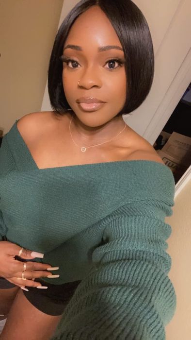 reviewer in a green off-shoulder sweater snapping a selfie